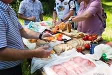 Menschen bedienen sich am reich gedeckten Picknicktisch in der Toskana